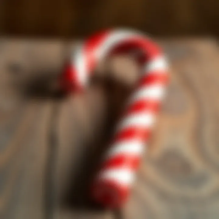 Close-up of a large striped red and white candy cane on a wooden surface